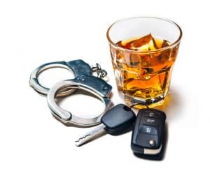 Whiskey with car keys and handcuffs concept for drinking and driving