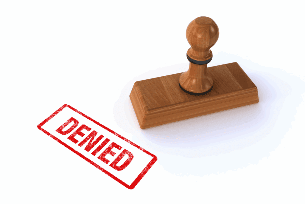 Wooden stamp with the word "DENIED" marked in red, depicting a judge’s authority to deny bail under proposed Texas constitutional amendments.