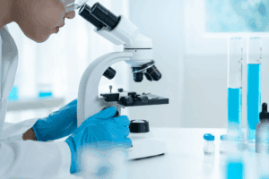 Lab technician examining a sample under a microscope to determine THC concentration.